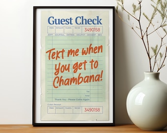 May include: A framed print of a vintage-style guest check with the text "Text me when you get to Chambana!" in orange lettering on a blue and white background.