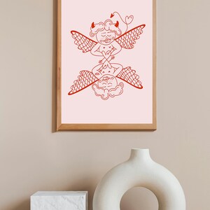 Könnte beinhalten: Eine gerahmte Illustration von zwei roten Linienzeichnungen von Figuren mit Flügeln. Die Figuren stehen sich gegenüber und scheinen in einer Yoga-Pose zu sein. Der Hintergrund ist hellrosa.