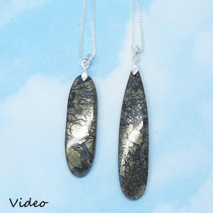 May include: Two silver necklaces with teardrop-shaped pendants made of a dark green and gold stone. The stone has a marbled pattern.