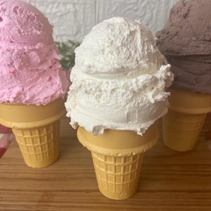 Pu&ograve; includere: Tre coni gelato decorativi con palline testurizzate nei colori rosa, bianco e marrone. Ogni pallina poggia su un cono beige con motivo a cialda. Le palline hanno un aspetto denso e montato con punte e creste visibili, che imitano il gelato vero.