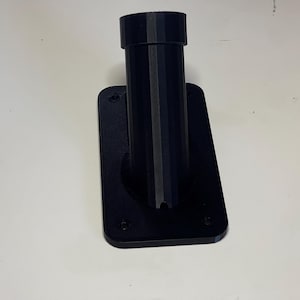 May include: Black plastic wall mount with a round opening for a pole or pipe.