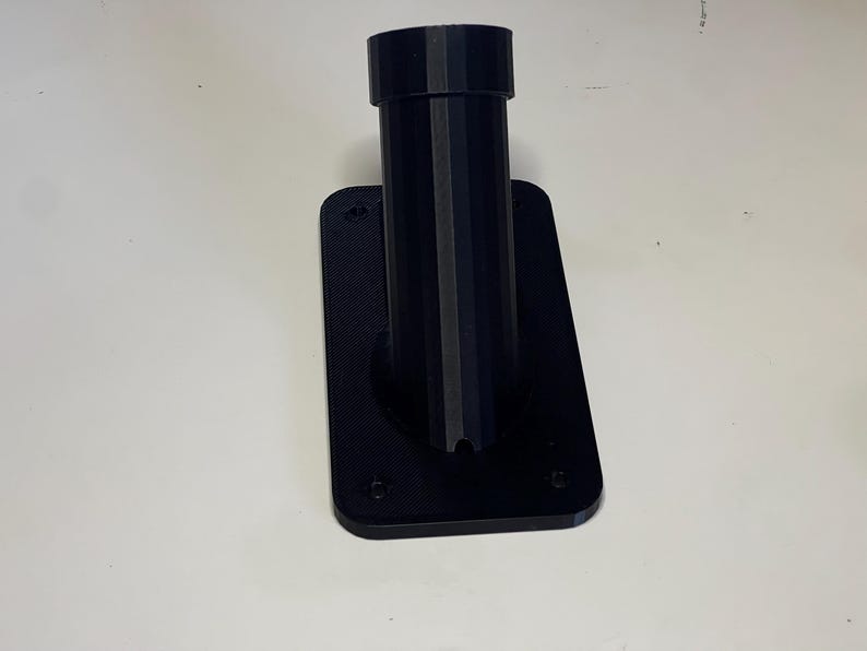 May include: Black plastic wall mount with a round opening for a pole or pipe.