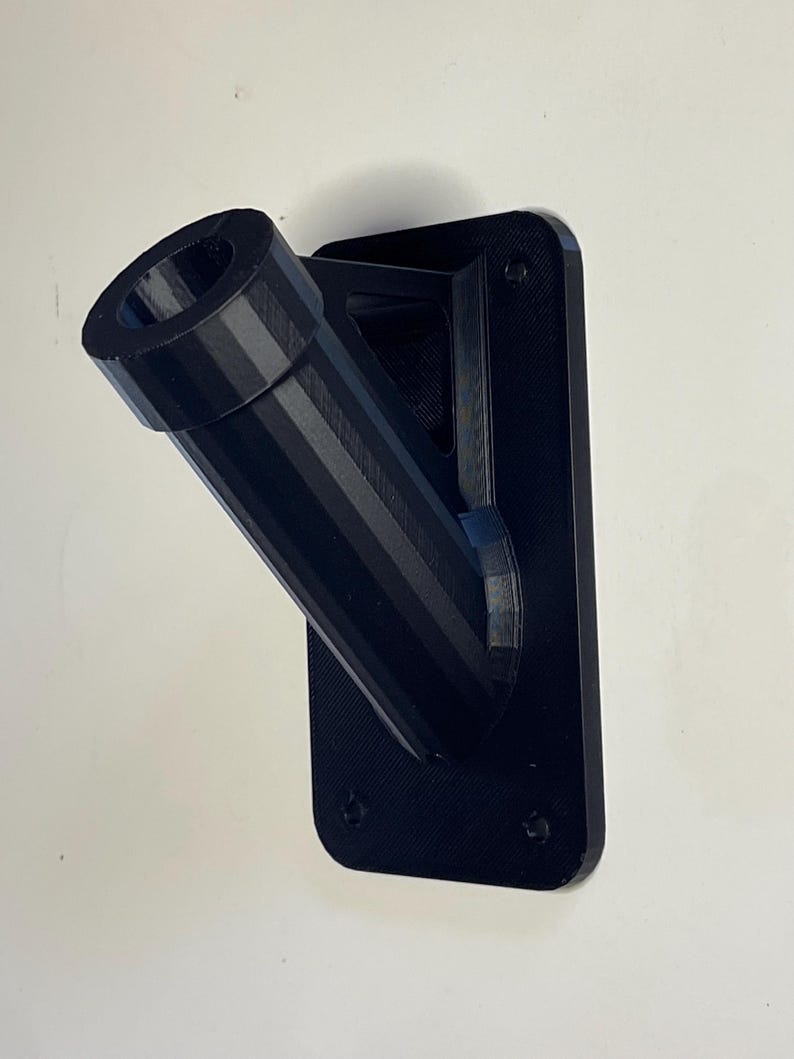 May include: Black plastic wall mount with a angled pipe for hanging a flag or banner.