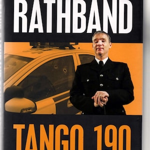 May include: Book cover for "PC David Rathband: The Gateshead Shootings and the Hunt for Raoul Moat." Features a man in a police uniform, a police car, and the title "Tango 190" in orange. Includes a quote by Alan Shearer.