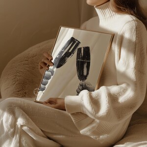 May include: A gold framed mirror with a black and white image of two champagne flutes clinking together.