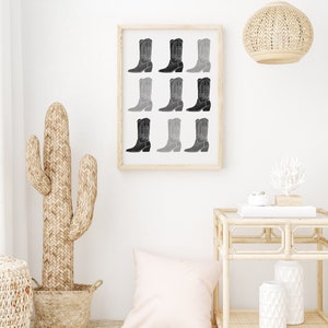 May include: A framed print of a black and white illustration of nine cowboy boots in a gradient pattern.