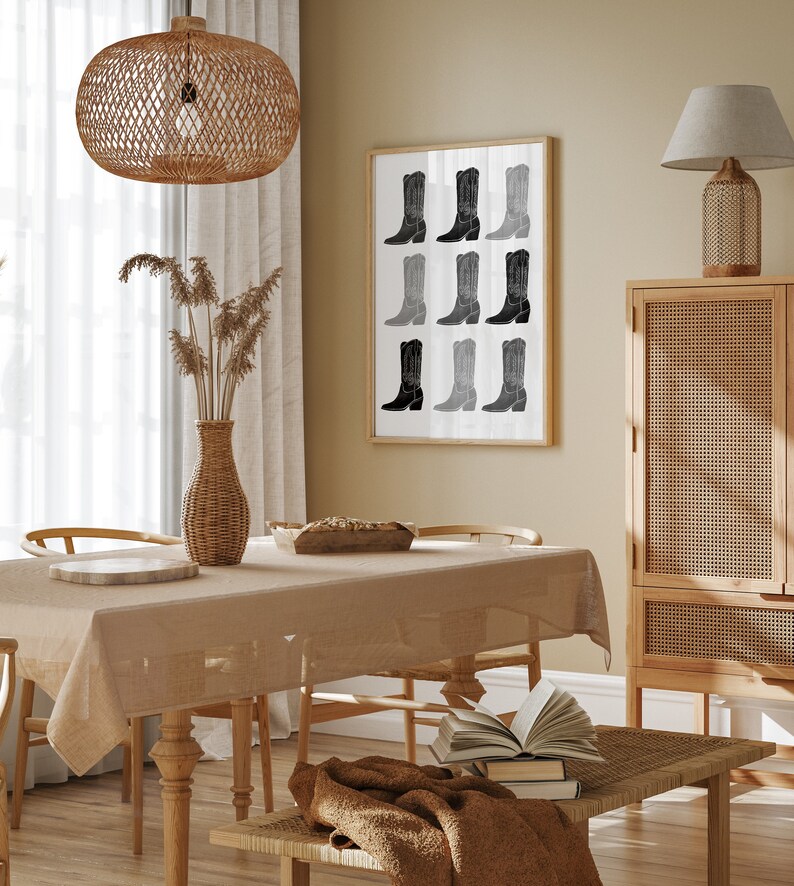 May include: A dining room with a wooden table and chairs, a woven light fixture, a framed print of black and white cowboy boots, a woven side table, and a woven cabinet.