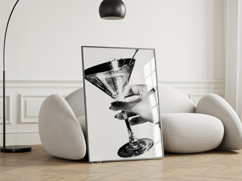 Puede incluir: Ilustraci&oacute;n en blanco y negro de una mano sosteniendo una copa de martini. La imagen est&aacute; impresa sobre un fondo blanco y enmarcada en un marco negro.