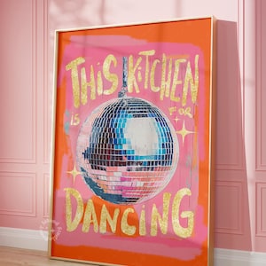 Könnte beinhalten: Ein rosa-oranger Leinwanddruck mit goldenen Glitzerbuchstaben, auf dem "This Kitchen is for Dancing" steht und ein großer silberner Discoball abgebildet ist.