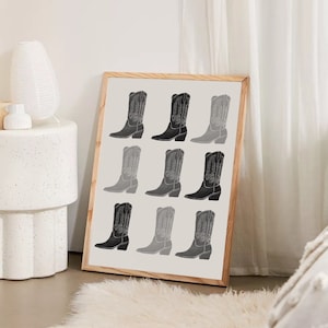 May include: A framed print with a black and white design of nine cowboy boots in a grid pattern.