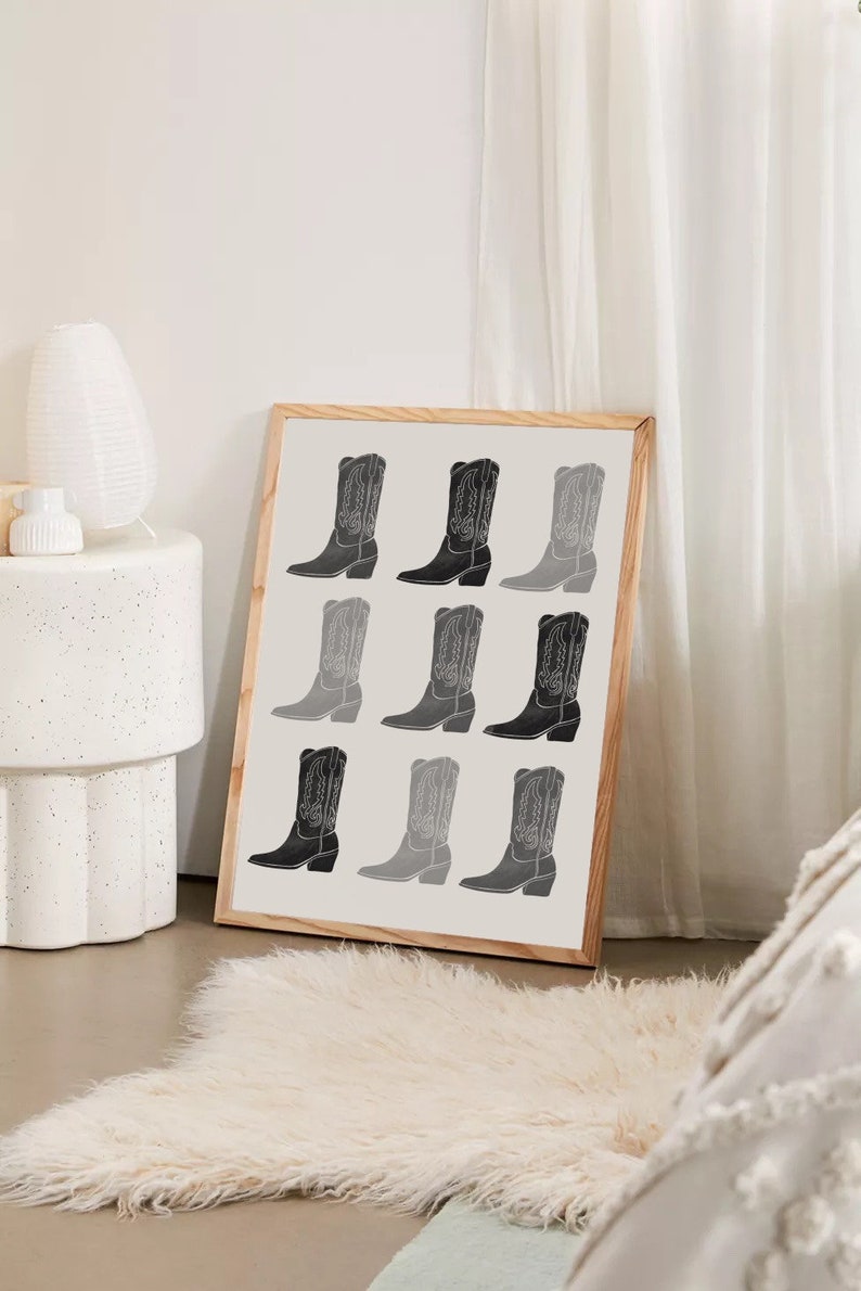 May include: A framed print with a black and white design of nine cowboy boots in a grid pattern.