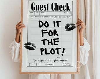 May include: A framed print resembling a guest check, featuring the words "Guest Check" at the top. Bold text reads "DO IT FOR THE PLOT!" with lipstick kiss marks. The frame is a light wood color.
