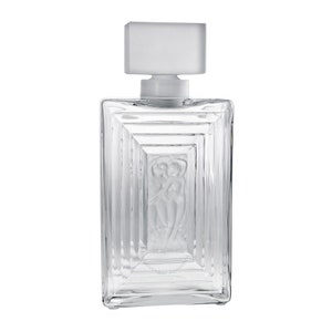 May include: A clear glass bottle with a frosted glass stopper. The bottle has a rectangular shape with a raised design of two figures embracing. The bottle is empty.