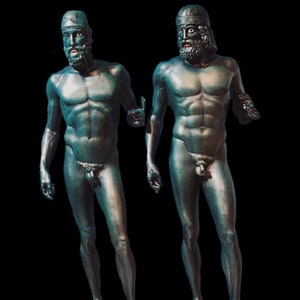 May include: Two bronze statues of nude men standing on square bases. Both statues are posed in a similar way, with their arms outstretched and their heads tilted slightly to the side. The statues are both painted in a dark green colour.