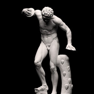 Könnte beinhalten: Eine weiße Marmorskulptur eines Mannes, der eine Diskus wirft. Die Figur steht auf einem Sockel mit einem Baumstamm hinter sich. Die Skulptur ist vor einem schwarzen Hintergrund platziert.