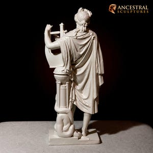 May include: A cream-colored sculpture of a figure playing a lyre. The figure is draped in classical robes and stands on a pedestal with a sculpted figure at the base. The sculpture is set against a black background. The text "ANCESTRAL SCULPTURES" is in the upper right corner.