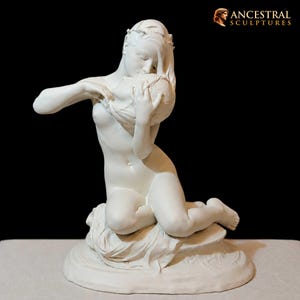 May include: A white matte sculpture depicting a figure kneeling on a draped base, holding a rounded object close to the face with both hands. The figure has long hair and is positioned in a forward-leaning posture. The text ANCESTRAL SCULPTURES appears.