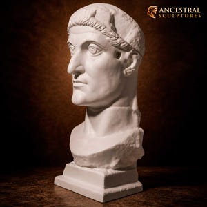 May include: A white stone bust of a person with a prominent nose, large eyes, and a short, textured hairstyle. The sculpture features a smooth, matte finish and rests on a rectangular base. The text ANCESTRAL SCULPTURES appears in the top corner.