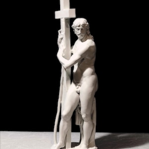 Puede incluir: Escultura de mármol blanco de un hombre llevando una cruz. La escultura es detallada y realista, con los músculos y los rasgos faciales del hombre claramente definidos.