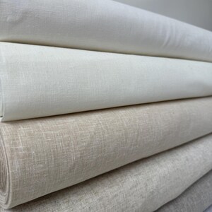 May include: Five rolls of fabric in various shades of beige and white. The fabric is a linen blend and has a subtle texture.