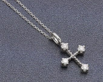 May include: A silver chain necklace with a small, silver cross pendant. The cross is adorned with small, clear diamonds.