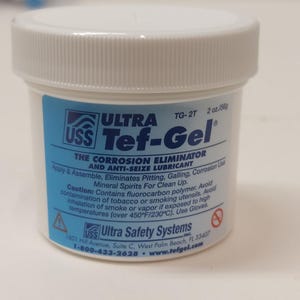 May include: A white plastic jar of Ultra Tef-Gel, a corrosion eliminator and anti-seize lubricant. The label is blue and white, with the product name and instructions. The jar contains 2 oz (56g) of the product.