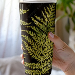 May include: A black and green stainless steel tumbler with a fern pattern. The tumbler has a clear lid.