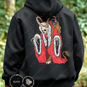 May include: Black hoodie featuring a skeletal figure in a red robe with white trim, a horned skull, and a tail. The graphic is on the back of the hoodie. The hoodie has a drawstring hood and a kangaroo pocket.