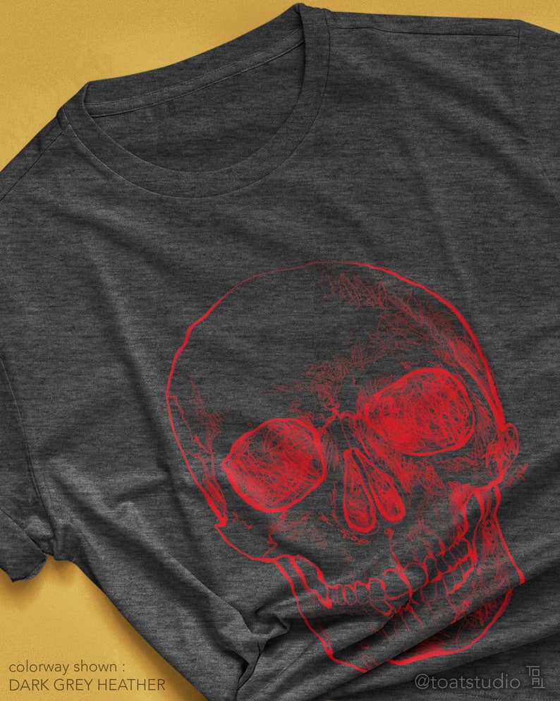 Pode incluir: T-shirt cinza escuro mesclado com um design de caveira vermelha. O gr&aacute;fico &eacute; uma representa&ccedil;&atilde;o art&iacute;stica e detalhada de uma caveira. O texto "colorway shown: DARK GREY HEATHER" &eacute; vis&iacute;vel na parte inferior da imagem.