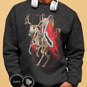 May include: Black sweatshirt featuring a skeletal figure riding a skeletal reindeer with large antlers. The rider wears a red coat and a skull-like face. Gold chains adorn the reindeer. The design is framed in a red rectangle.