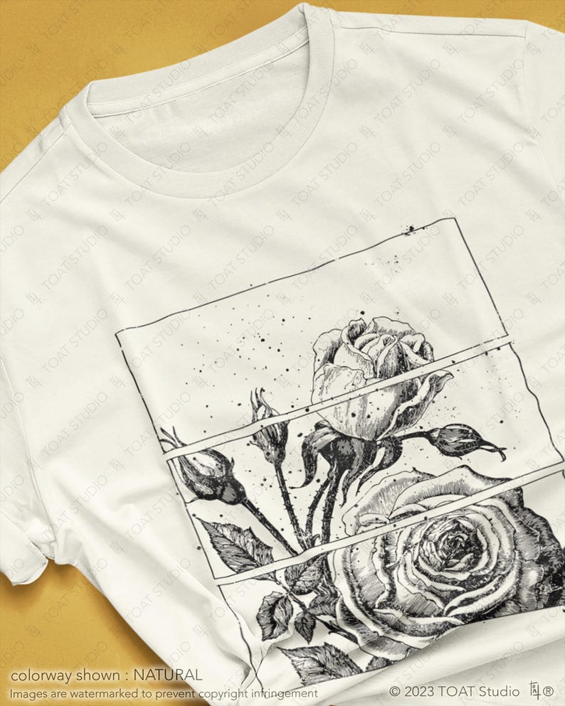 May include: A white t-shirt featuring a detailed black and white rose illustration within a rectangular frame. The design includes a large open rose, buds, and leaves. The shirt's colorway is natural.