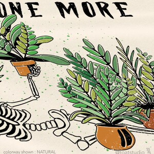 May include: Cream-colored graphic tee featuring a skeleton tending to potted plants. The words "ONE MORE" are at the top. The plants are green, and the pots are brown. The text "colorway shown : NATURAL" is at the bottom.