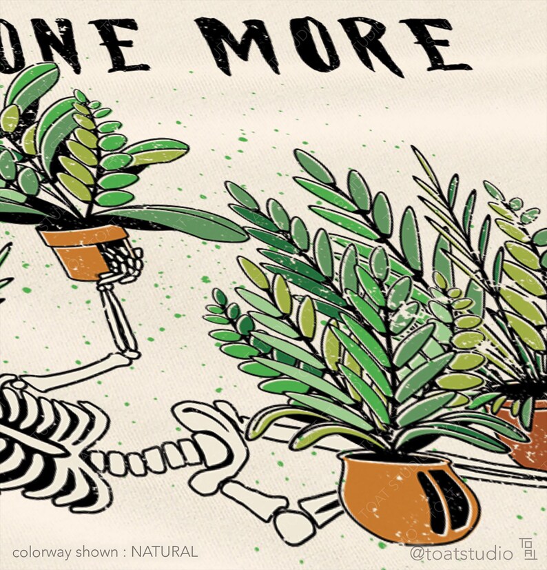 May include: Cream-colored graphic tee featuring a skeleton tending to potted plants. The words "ONE MORE" are at the top. The plants are green, and the pots are brown. The text "colorway shown : NATURAL" is at the bottom.