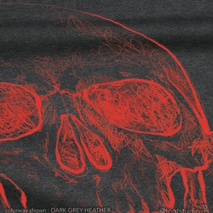 Pode incluir: Tecido cinza escuro mesclado com um desenho de caveira vermelha. A caveira &eacute; desenhada com um estilo rabiscado e art&iacute;stico. O texto na parte inferior diz "colorway shown: DARK GREY HEATHER".