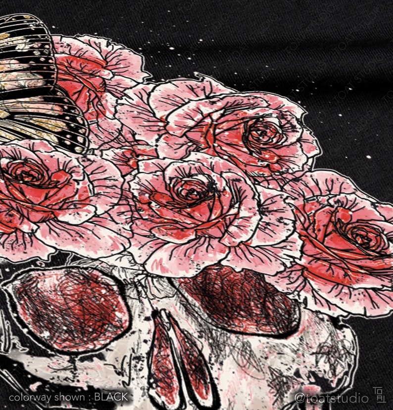 May include: Black graphic design featuring a skull with a bouquet of pink roses and a butterfly. The artwork is detailed with red and black shading, set against a black background. The text "colorway shown: BLACK" is visible.