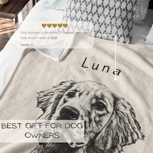 May include: A beige fleece blanket featuring a black and white illustration of a dog's head. The dog's name "Luna" is written in black text above the dog's head. The text "BEST GIFT FOR DOG OWNERS" is written in black text at the bottom of the blanket.