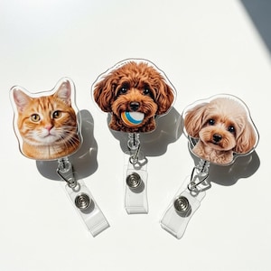 May include: Three pet-themed retractable badge holders. One features an orange tabby cat, and the other two feature different breeds of dogs. The dogs are brown and tan, and one is holding a ball. Each badge holder has a clear plastic strap and a metal clip.
