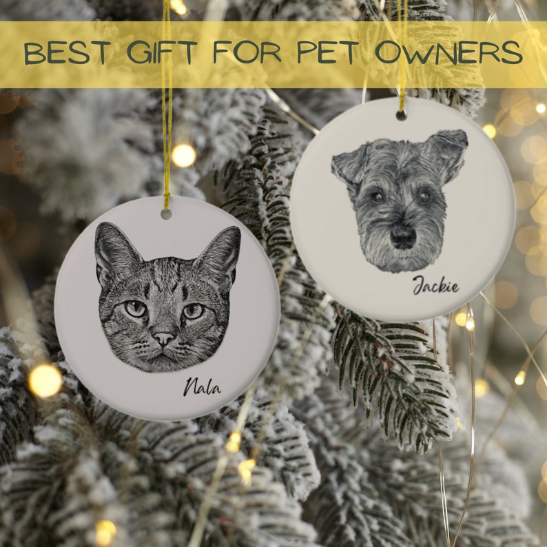 Puede incluir: Dos adornos navide&ntilde;os de cer&aacute;mica blanca con ilustraciones en blanco y negro de un gato y un perro. El adorno del gato tiene el nombre "Nala" escrito debajo de la imagen. El adorno del perro tiene el nombre "Jackie" escrito debajo de la imagen.