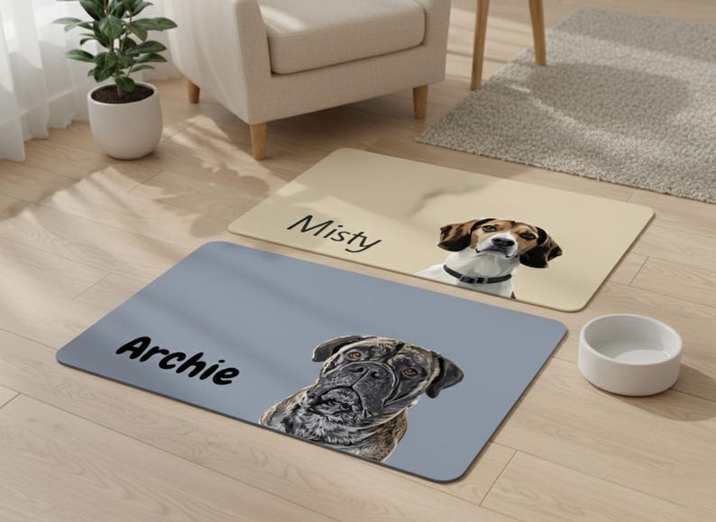May include: Two rectangular pet mats with dog portraits and names. One is beige with "Misty" and a beagle. The other is gray with "Archie" and a mastiff. A white dog bowl sits nearby.
