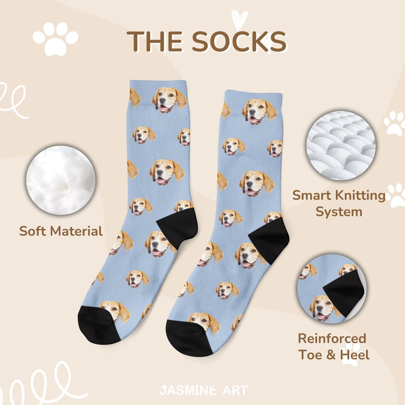 May include: A pair of blue socks with a repeating pattern of a dog's face. The socks have black heels and toes. The text "THE SOCKS" and "JASMINE ART" are visible on the image.