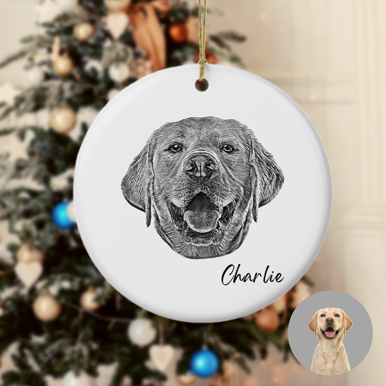 Puede incluir: Un adorno navide&ntilde;o de cer&aacute;mica blanca con una ilustraci&oacute;n en blanco y negro de la cabeza de un Labrador Retriever. El perro est&aacute; sonriendo y el adorno est&aacute; personalizado con el nombre "Charlie".