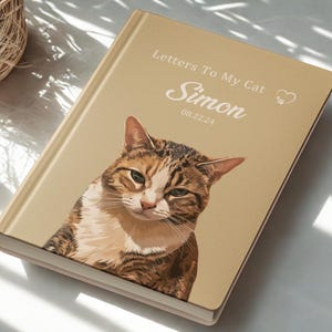 Pode incluir: Um di&aacute;rio de capa dura com um retrato de gato na capa. O t&iacute;tulo &eacute; "Letters To My Cat", com o nome "Simon" e a data "08.22.24". O gato &eacute; retratado em tons de castanho, branco e bege, com um s&iacute;mbolo de cora&ccedil;&atilde;o.