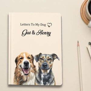 Pode incluir: Um caderno creme intitulado "Letters To My Dog" com os nomes "Gus & Henry" em escrita elegante. A capa apresenta uma ilustra&ccedil;&atilde;o em aquarela de dois c&atilde;es. Um l&aacute;pis, uma x&iacute;cara de caf&eacute; e um bloco de notas tamb&eacute;m s&atilde;o vis&iacute;veis.