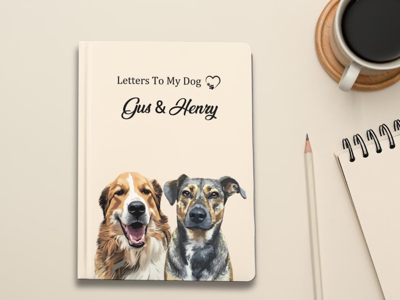 Pode incluir: Um caderno creme intitulado "Letters To My Dog" com os nomes "Gus & Henry" em escrita elegante. A capa apresenta uma ilustra&ccedil;&atilde;o em aquarela de dois c&atilde;es. Um l&aacute;pis, uma x&iacute;cara de caf&eacute; e um bloco de notas tamb&eacute;m s&atilde;o vis&iacute;veis.