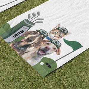 May include: White golf towel featuring a golf bag with clubs and the name "Mason". The towel has images of a cat and two dogs wearing golf hats with names "Lucy", "Zoey", and "Gus". A green flag and golf ball are also on the towel.