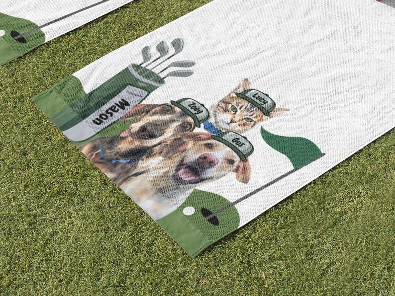 May include: White golf towel featuring a golf bag with clubs and the name "Mason". The towel has images of a cat and two dogs wearing golf hats with names "Lucy", "Zoey", and "Gus". A green flag and golf ball are also on the towel.