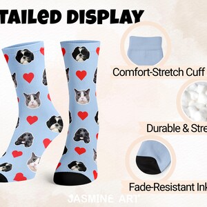 May include: Light blue socks with a pattern of dog and cat faces and red hearts. The socks have black heels and toes. The text "DETAILED DISPLAY" is at the top. The socks are described as having a comfort-stretch cuff, durable and stretchy, and fade-resistant ink.