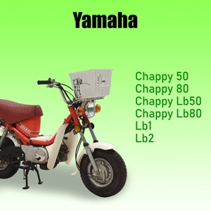 Può includere: Un ciclomotore Yamaha bianco con una sella rossa e un cestino bianco sul manubrio. Il ciclomotore ha uno scarico cromato e un faro cromato. Il testo "Yamaha" è visibile sul lato del ciclomotore. Il testo "Chappy 50", "Chappy 80", "Chappy Lb50", "Chappy Lb80", "Lb1" e "Lb2" è visibile sul lato destro dell'immagine.