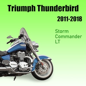 May include: A blue and silver Triumph Thunderbird motorcycle with a windshield. The motorcycle has a chrome exhaust and whitewall tires. The text "Triumph Thunderbird 2011-2018 Storm Commander LT" is visible in the image.