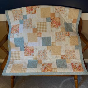 Handmade pink and teal baby quilt, peach, tan, floral, low volume prints.